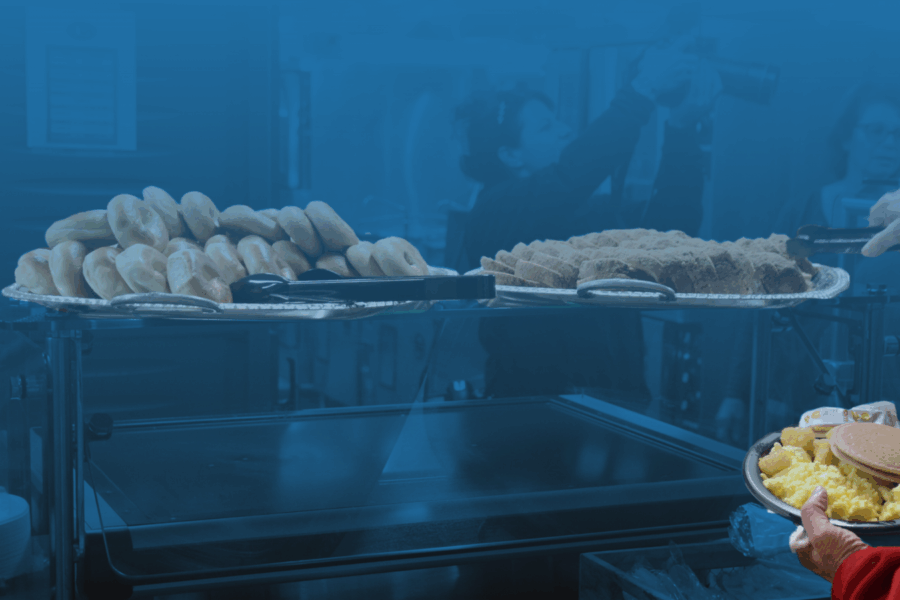 Person grabbing breakfast food from the EHS cafeteria buffet.