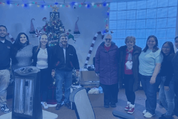 People standing in a row next to a box of donated items.