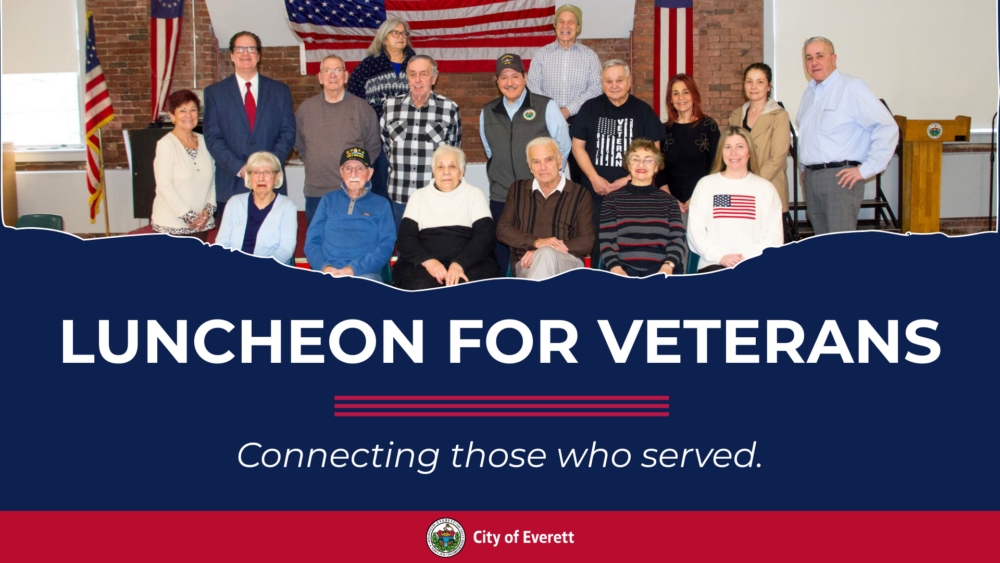 Promotional graphic for a “Luncheon for Veterans” featuring a group photo of veterans and community members standing and seated in front of an American flag. Text reads: “Luncheon for Veterans – Connecting those who served.”