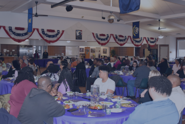 Community members sit at round tables with purple tablecloths during a last year's Women's History Month luncheon inside the Connolly Center.