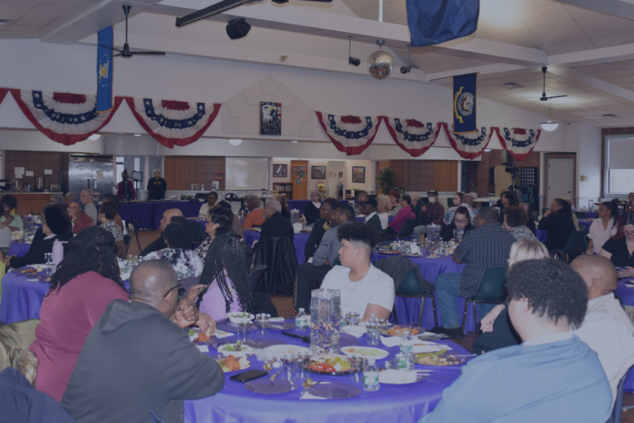 Community members sit at round tables with purple tablecloths during a last year's Women's History Month luncheon inside the Connolly Center.