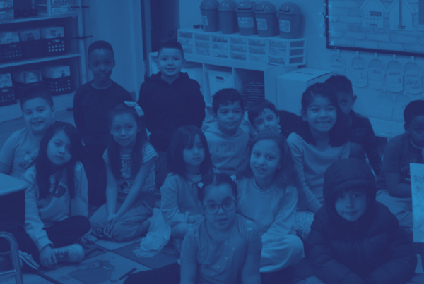 Children sit in a classroom smiling