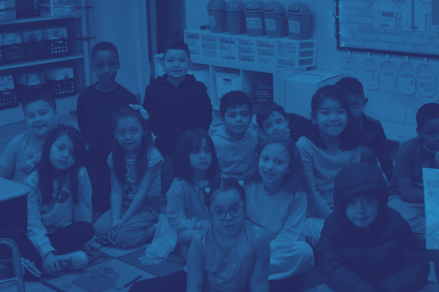 Children sit in a classroom smiling