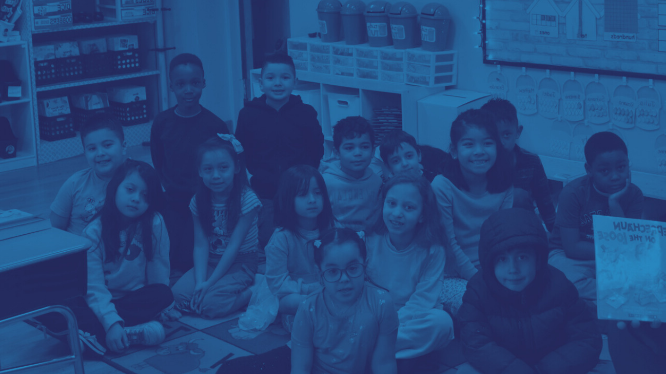 Children sit in a classroom smiling