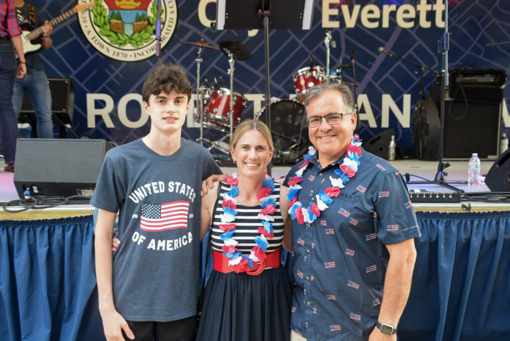 Mayor poses in front of stage with First Lady and their son.