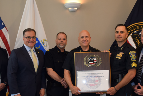 MPAC Board Member Juliann Flaherty, Mayor Robert Van Campen, Captain Paul Molea, Everett Police Chief Police Paul Srong, Everett Sergeant Nick Crowell, MPAC Executive Board Member Christopher Delmonte pose together for a picture holding the plaque certification.