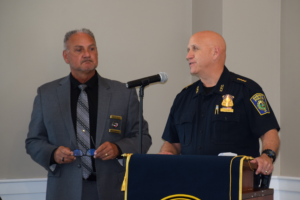 Chief Paul Strong standing at a podium accepting the certification at the MPAC ceremony 