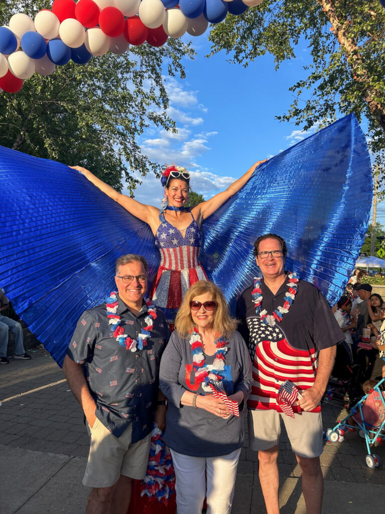 Mayor and his Assistants pose with patriotic stilt-walker at Celebration.