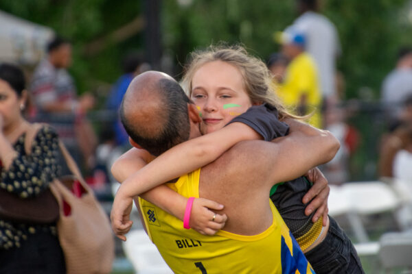 Man hugs his daughter celebrating at Fan Fest.