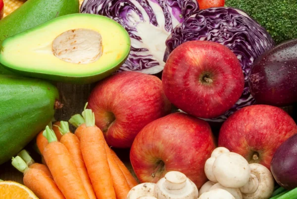 Picture of avocados, oranges, carrots, mushrooms, purple onions, apples, corn and tomatoes