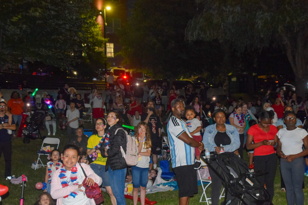 Crowd watches as fireworks show begins.