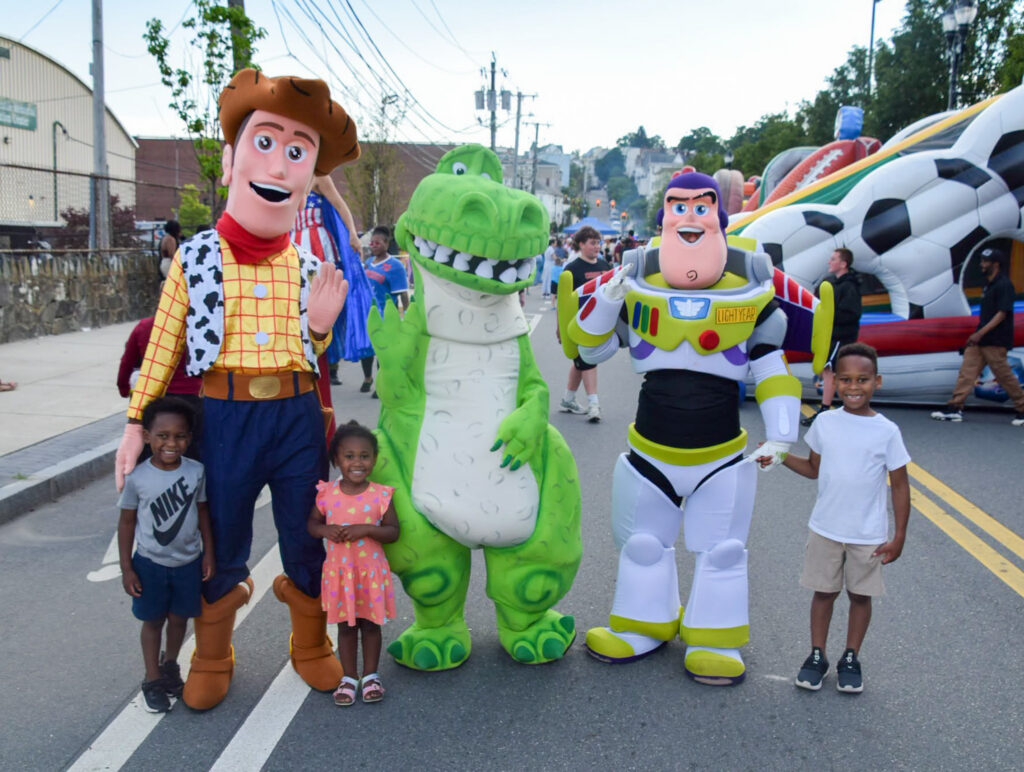Children pose with characters from animated movies.