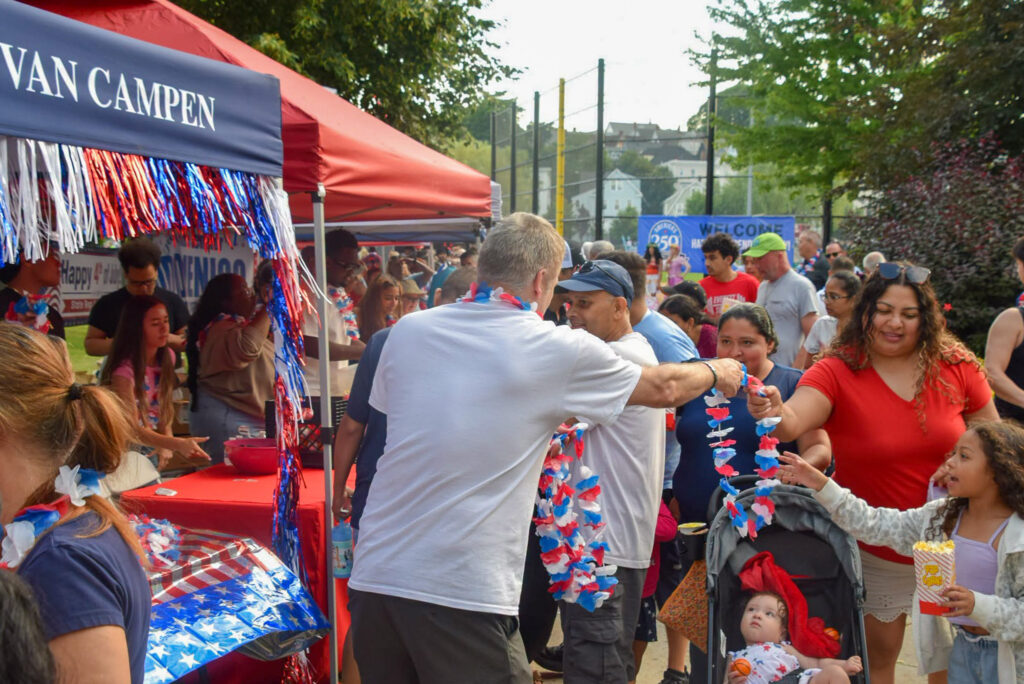 Mayor Van Campen's tent hands out red white and blue leis to residents.