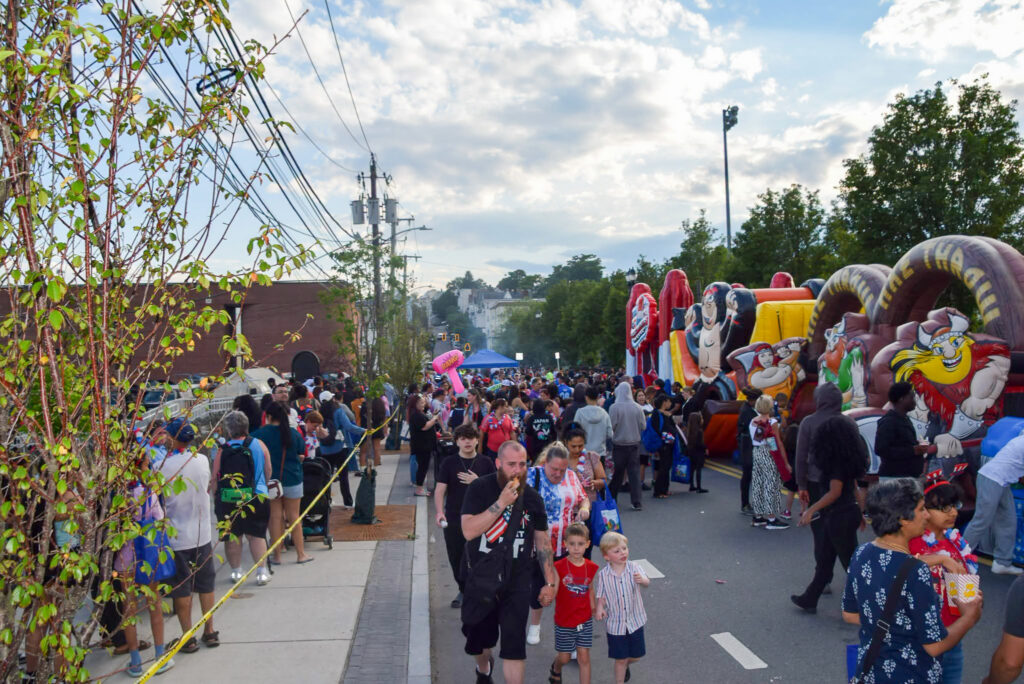 Crowd on the street with inflatables lining the side.