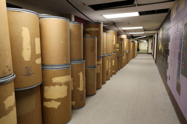 dozens of cylinder shaped barrels line the hallway at the old Everett High School.