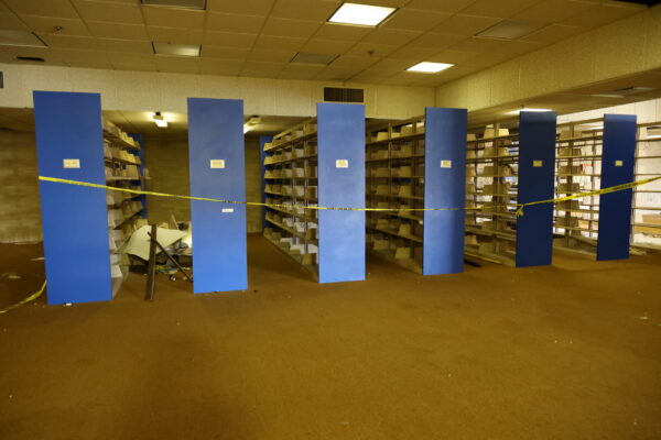 Six large bookstands in what used to be the library with a piece of caution tape hanging across the side