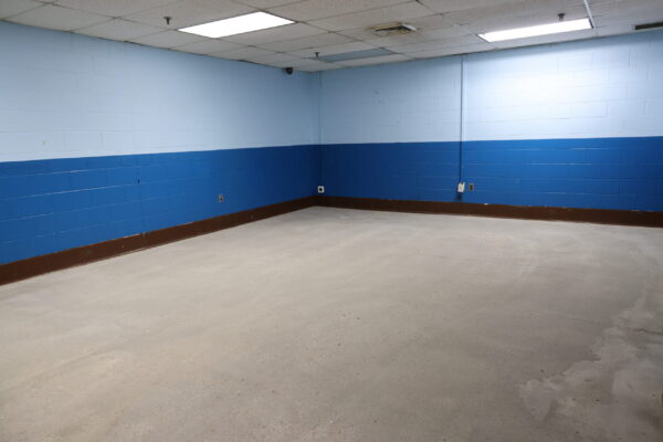 An empty room with blue walls showing the tiles have been removed and remediation is complete