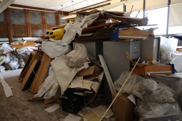 A giant pile of debris including old cabinets, trash and materials collected from around the school