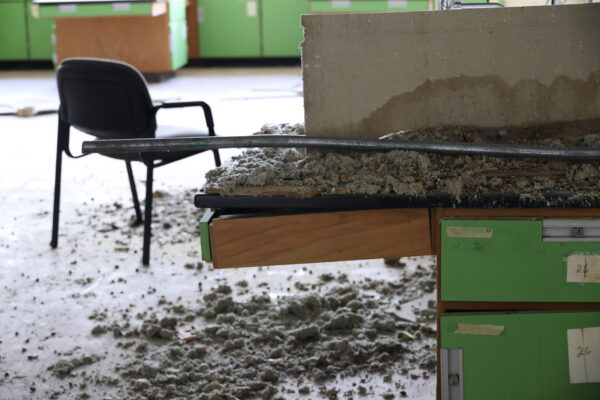 An old science classroom with debris on the lab table and a chair in the middle of the room