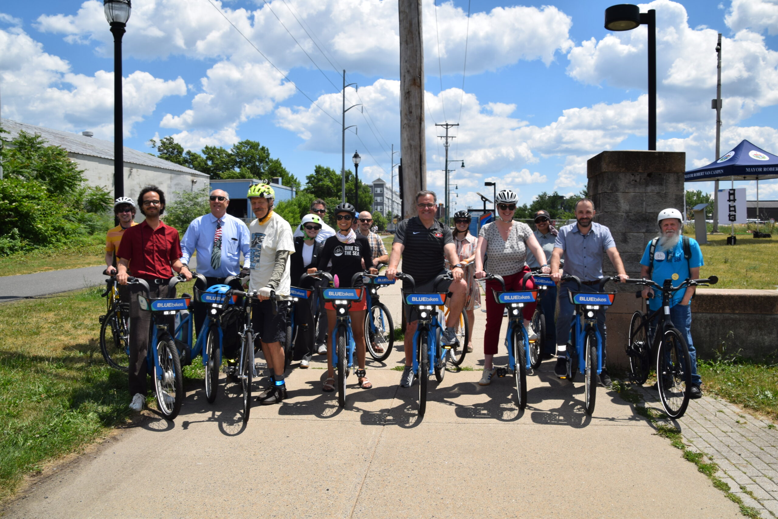 Group photo of Mayor Van Campen, members of MassDOT and community partners outside in the sun on the Northern Strand trail