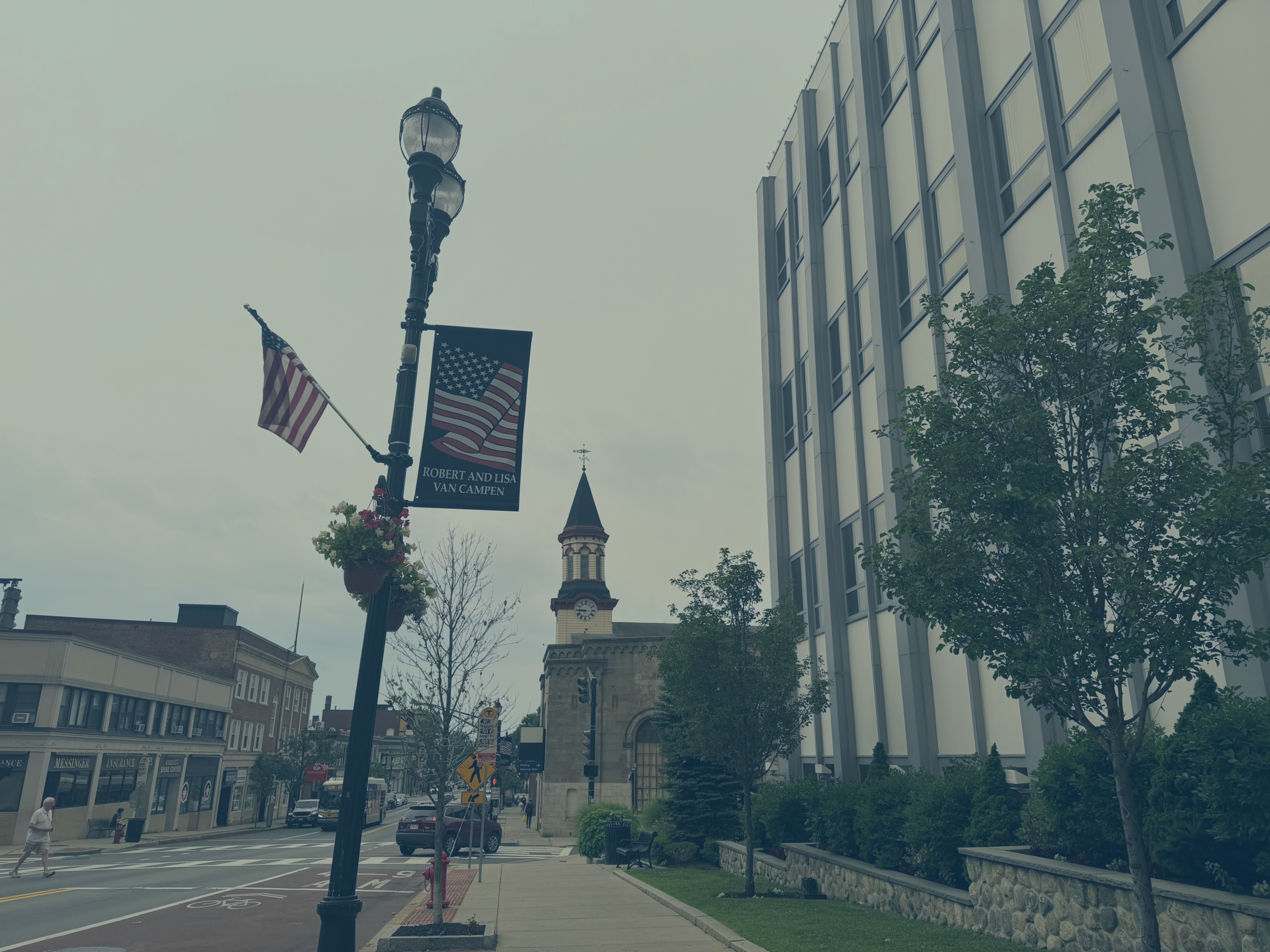 Street view outside city hall showing a light pole with one of the flag banners