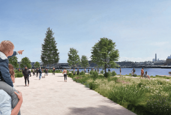 A render of the waterfront park with a pedestrian walkway, trees, and water transport on the river.