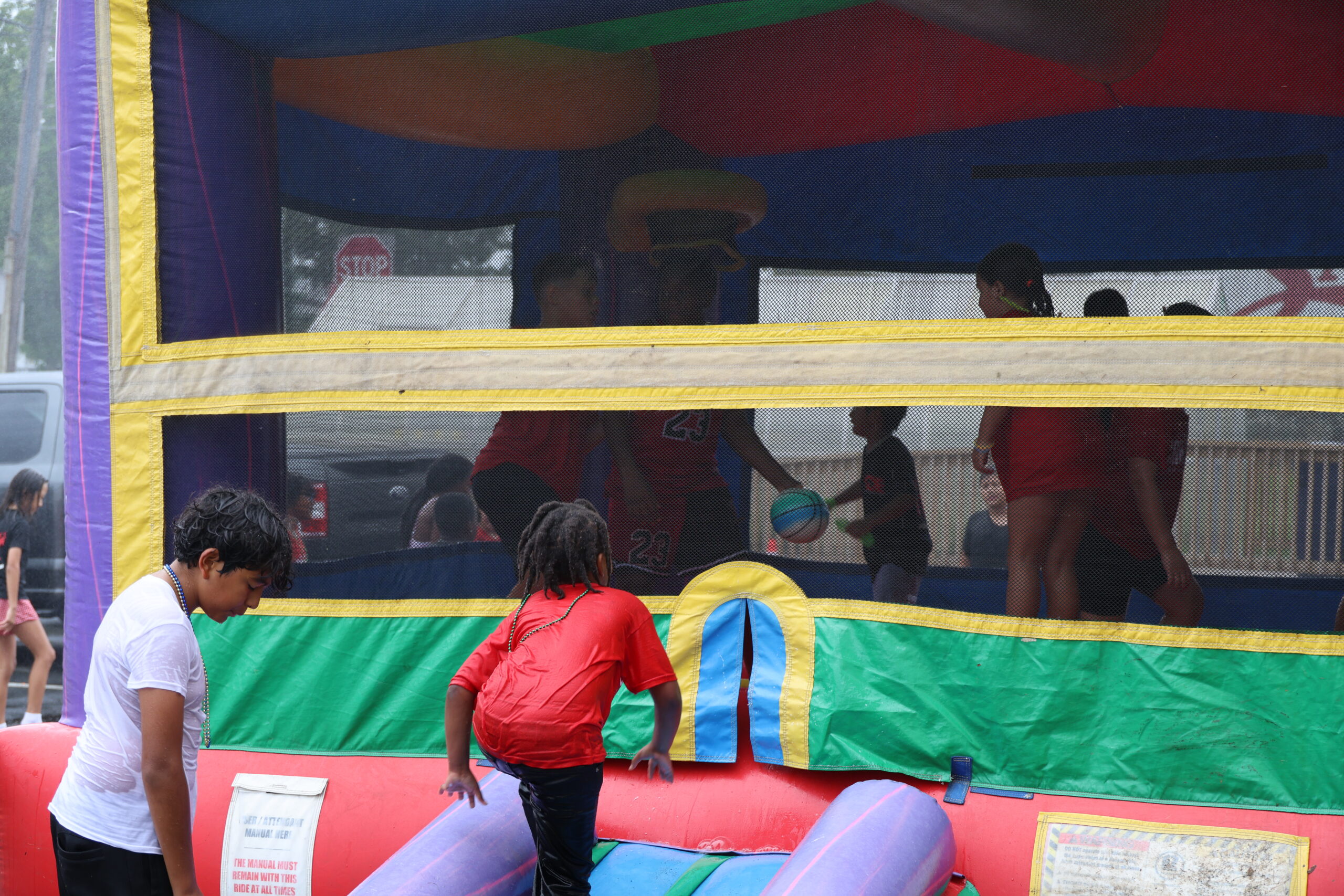 Kids playing in bouncy house at Crimson Kids Summer Program