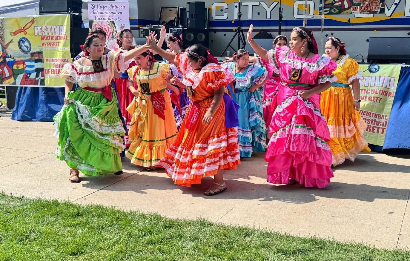 Dancers in vibrant cultural dresses at 2024 Everett Multicultural Festival.
